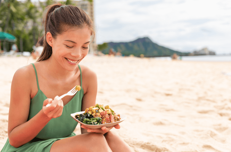 Woman eating on the beach with blurred background