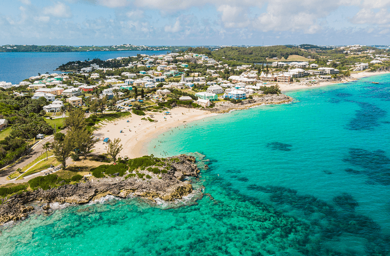 A picturesque Caribbean island dotted with houses and surrounded by azure waters.