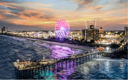 Aerial view of the Myrtle Beach Pier and illuminated SkyWheel Myrtle Beach just after a sunset.