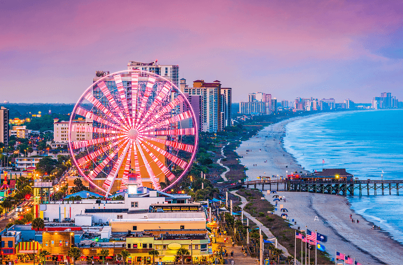 Beautiful Myrtle Beach, the Myrtle Beach Pier, and the illuminated SkyWheel Myrtle Beach in the late evening.