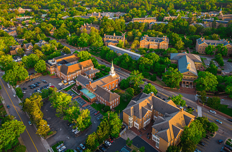 A look down at Williamsburg, Virginia, from above with many brick buildings and trees scattered about.