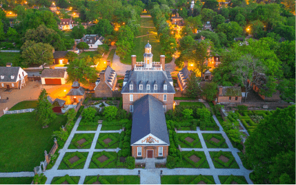 Aerial view of the Governor’s Palace and grounds illuminated at night in Colonial Williamsburg.
