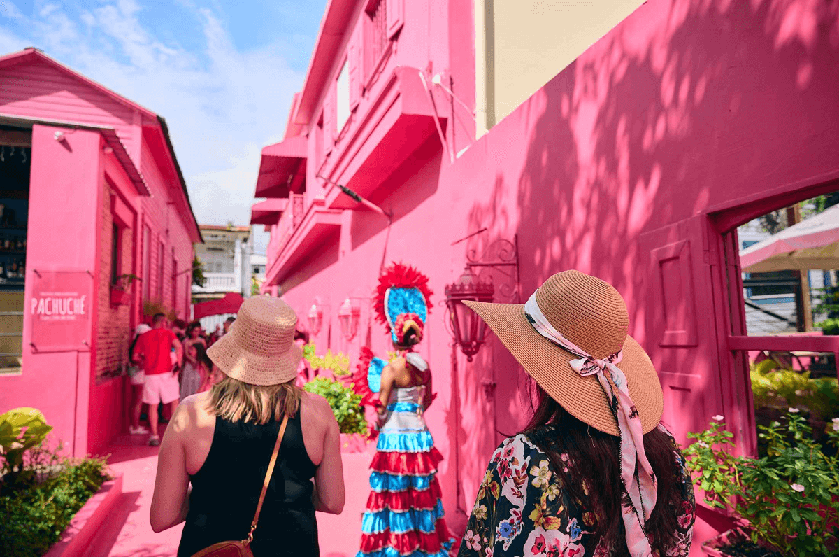 Two women exploring the pink streets of Dominican Republic.
