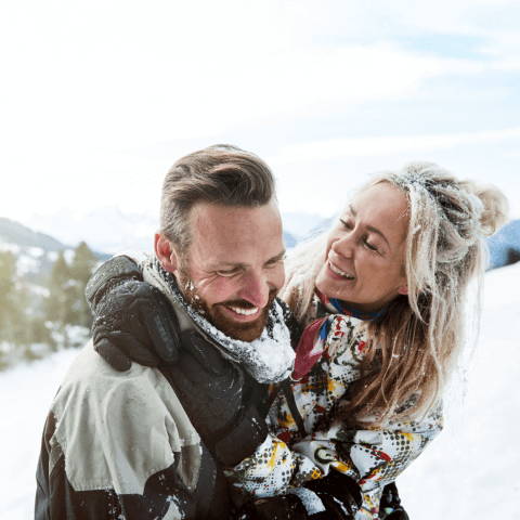 A couple enjoying a snowy day with an embrace.