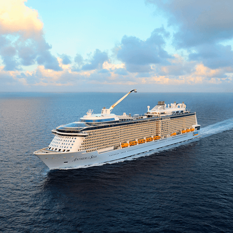 Aerial view of a cruise ship at sea with a clear sky in the background