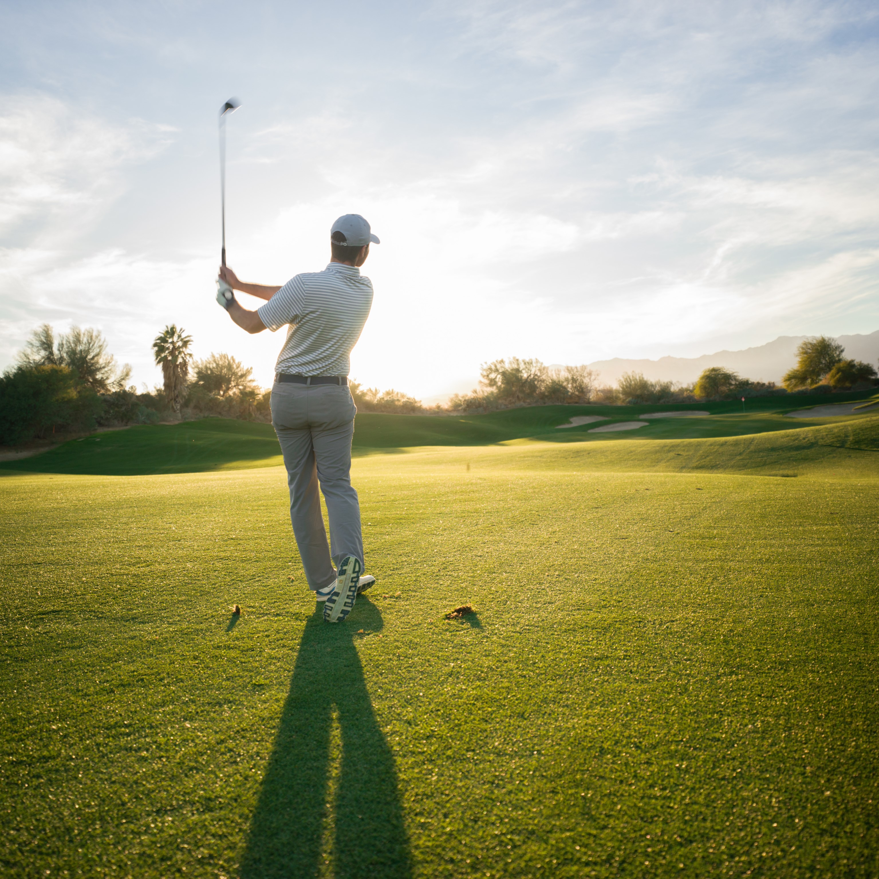 Man playing golf and teeing off