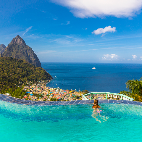 A woman relaxing in a swimming pool, surrounded by water and sunlight.