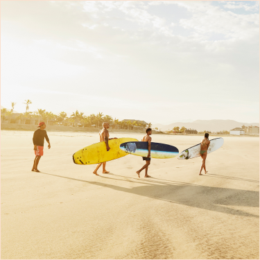 A group of people with surfboards on a sandy beach.