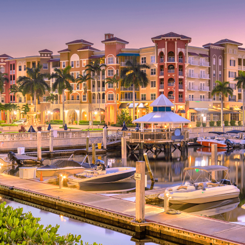 A serene marina at sunset, featuring several boats docked peacefully against a colorful sky.