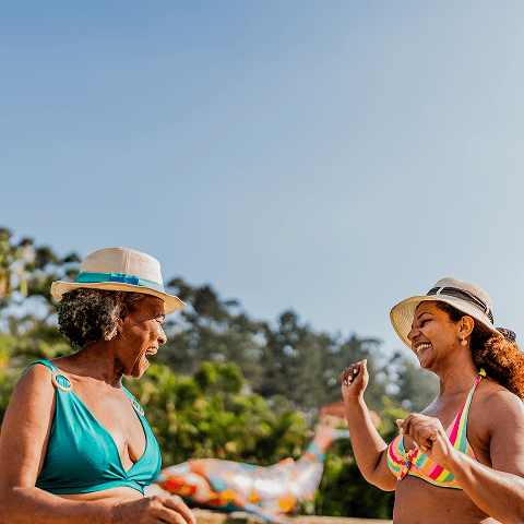 Two ladies enjoying a sunny beach day.