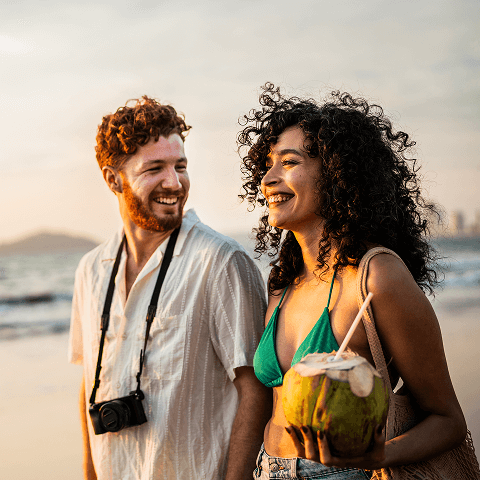 Two people enjoying a walk on the beach.