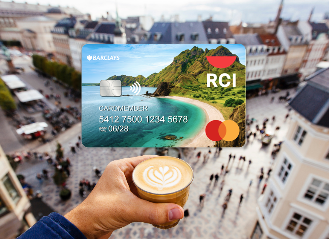 A Barclays RCI credit card juxtaposed on a view of someone's latte in street of Europe.