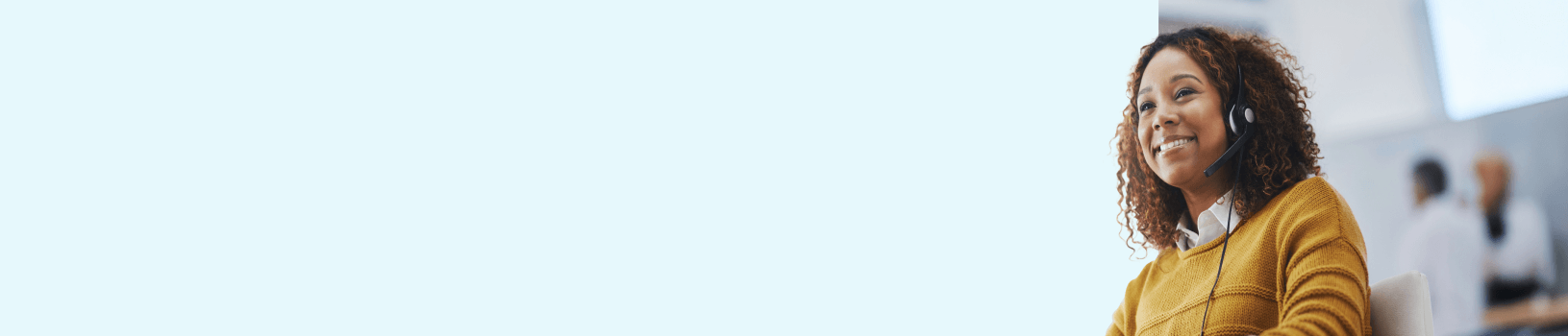 A smiling woman sitting in a white chair and wearing a headset.