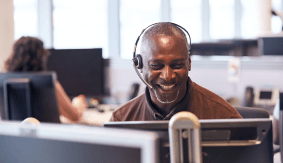 Man smiling attending a call on a call center