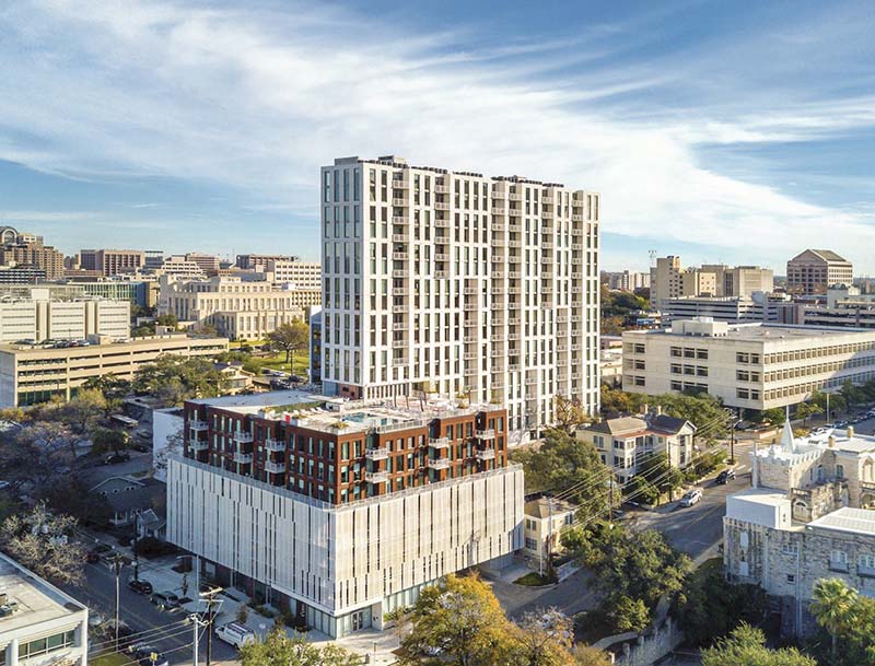 A bird's-eye view of the Club Wyndham Austin resort and its rooftop pool with the city of Austin in the background.