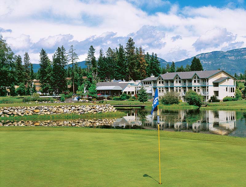 A scenic view of the golf course surrounding the resort, with majestic mountains visible in the distance.