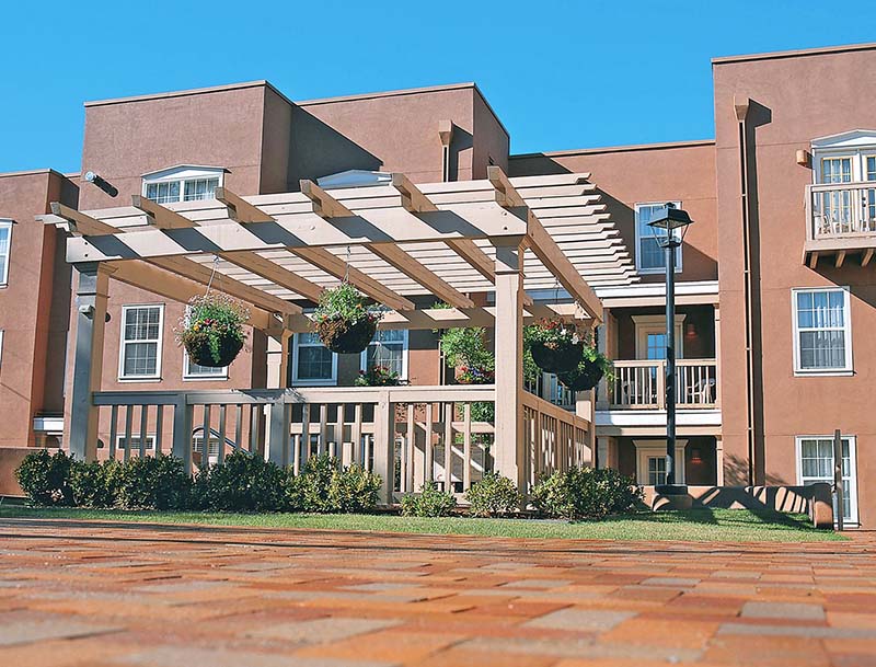 A view of a modern adoble-style building at the Villas De Santa Fe.