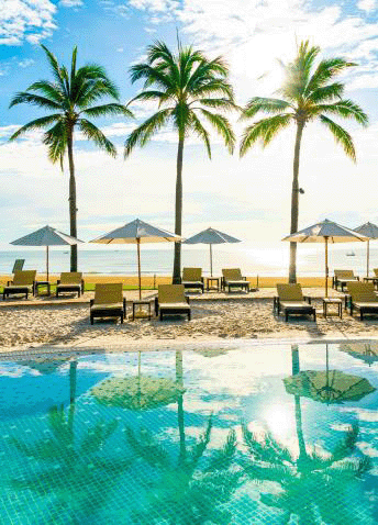 Tranquil blue skies and jewel waters by a cabana on a tropical beach.