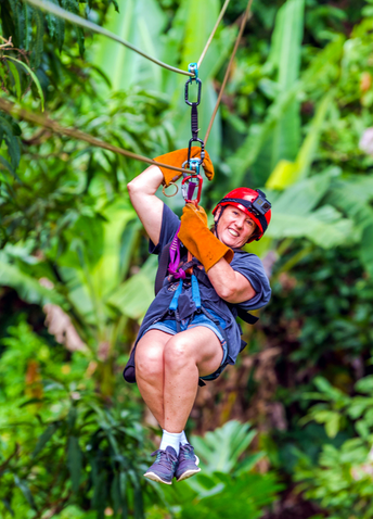 A woman ziplining in a forest